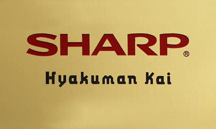 Sharp-Hyakuman-Kai-Award The image shows a gold background with the word SHARP in large red letters above Hyakuman Kai in smaller black text, alongside the GoodSuite logo.